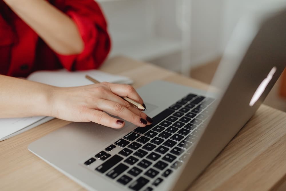 Business owner working on a laptop while planning website content and digital marketing strategy at a desk.